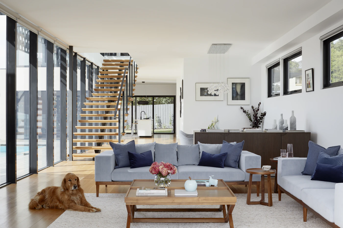 Warm living room with timber furnishings, soft textiles, and a sculptural chair
